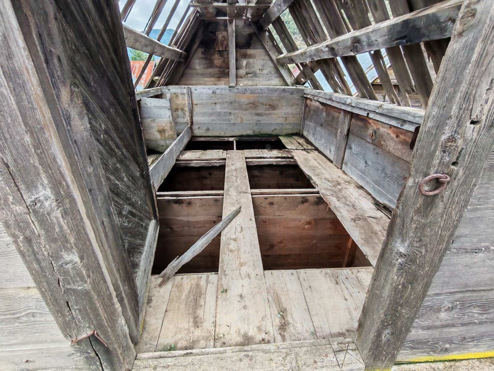 Ahşap eski bir kulübe veya evin tavan ve zemin yapısı, birkaç boşluk ve çatlak var, hasar görmüş ve kullanılmaz durumda.