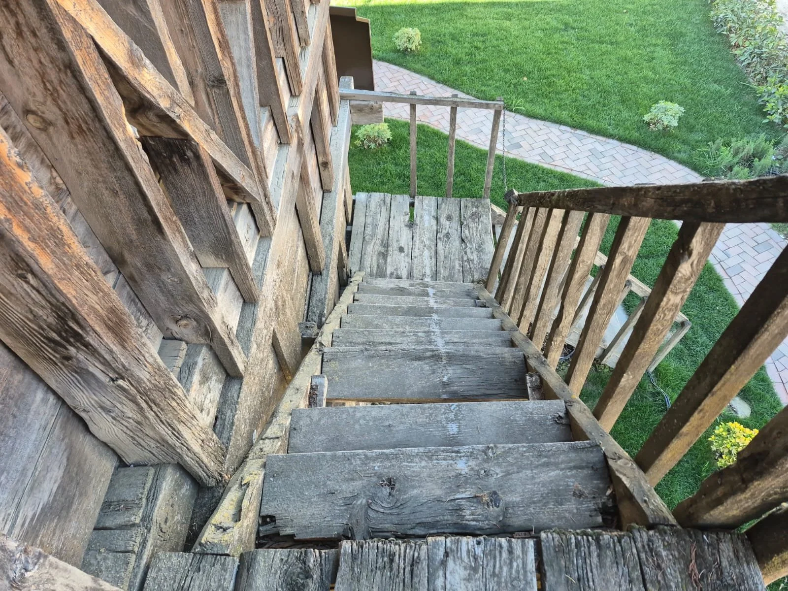 Ahşap merdiven ve korkuluklar ile dış mekan bahçe manzarası.