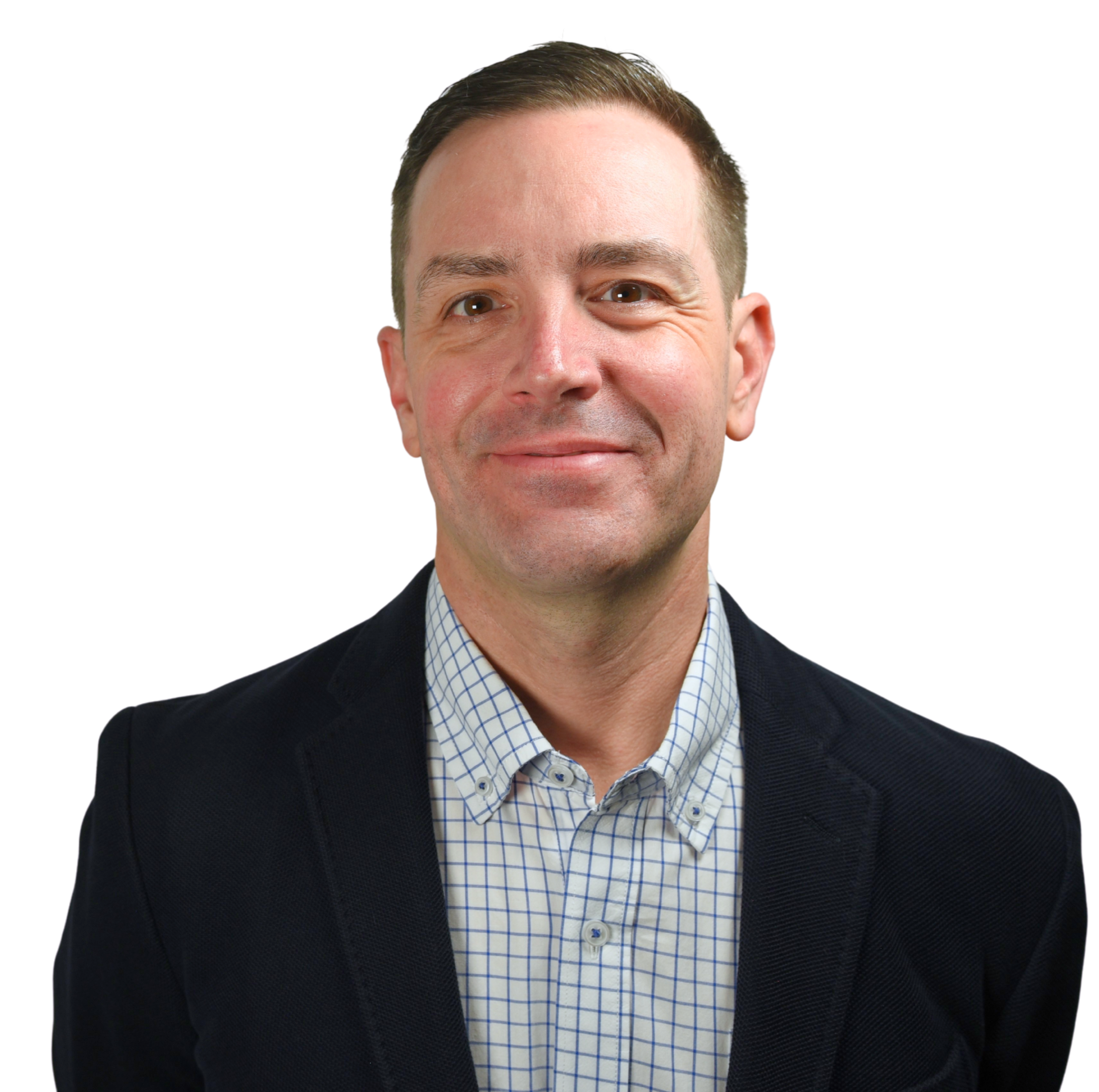 Image of Jason Magennis, high performance coach, wearing a dark blazer and a checkered shirt, smiling at the camera.