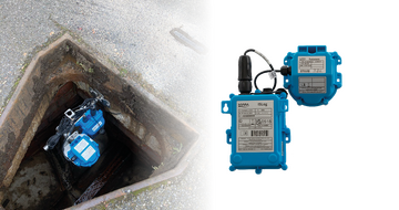 A blue utility inspection camera inside a hole in the ground, with a portable electronic device beside it.