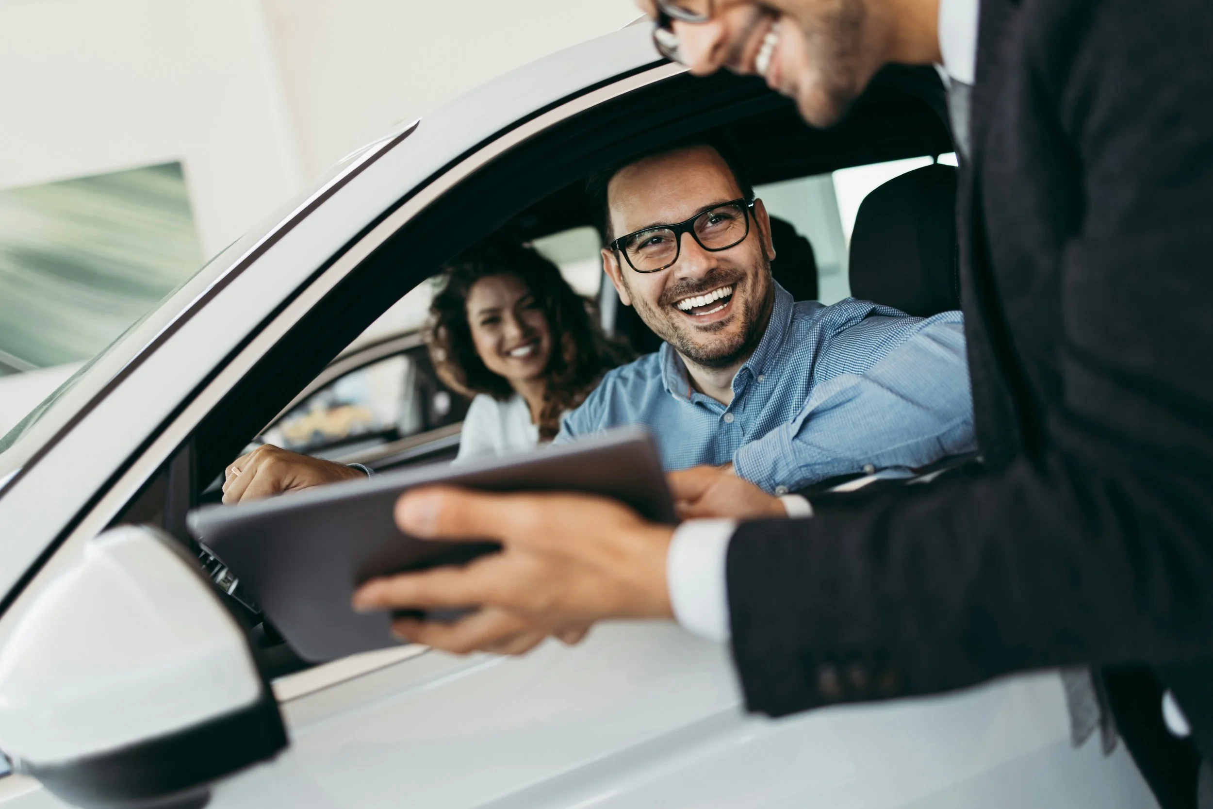 couple finalizing a car purchase with a car dealer