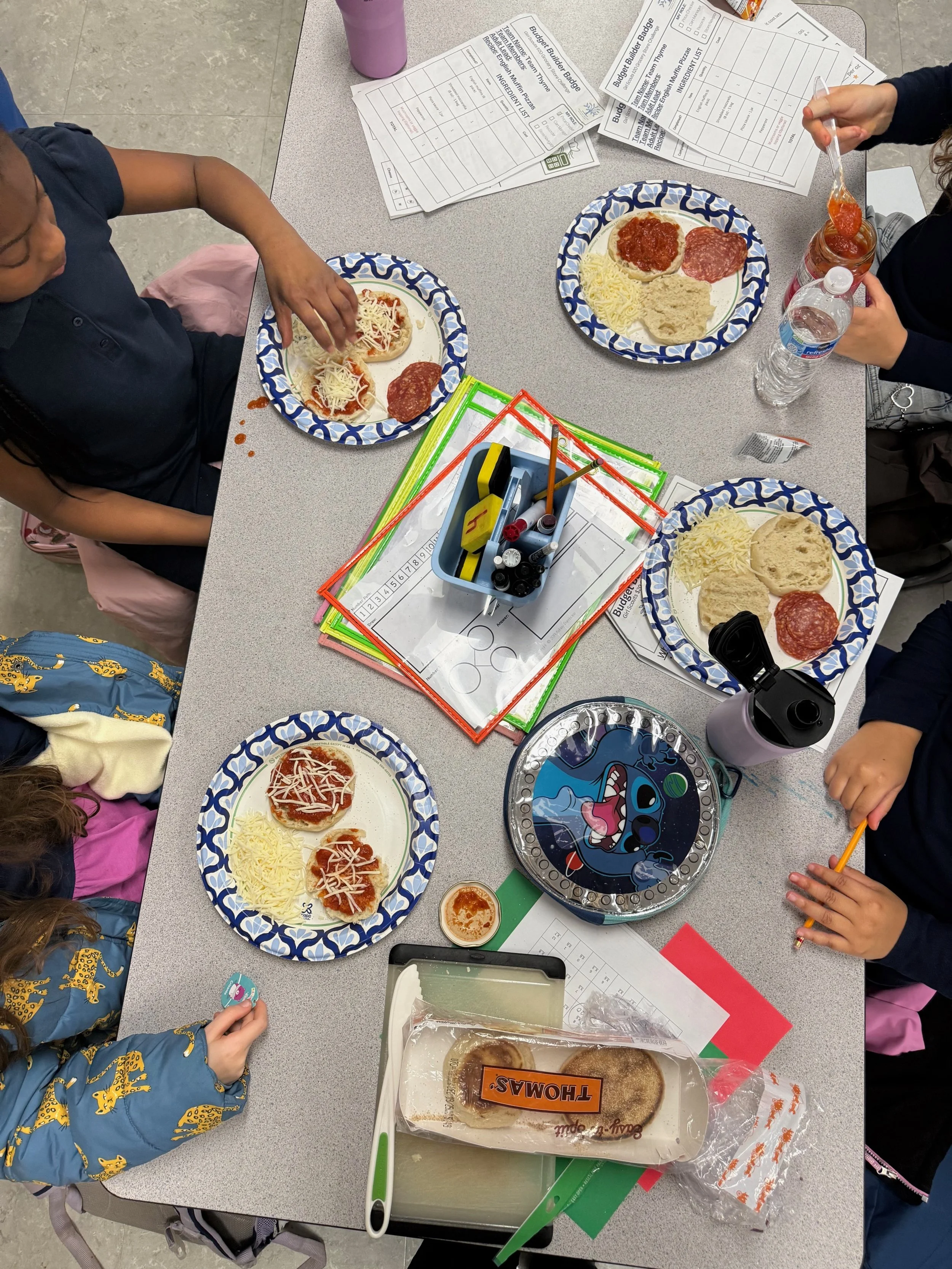 Team of 3rd graders making english muffin pizzas after a budgeting workshop