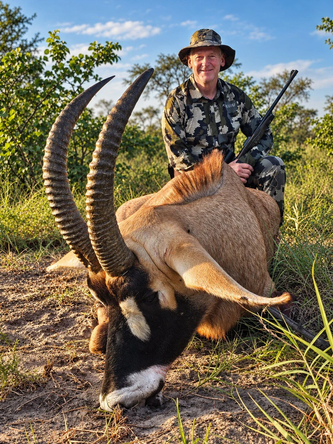The Long Curve of Horns
A long-horned antelope is pictured with a person behind it in the brush.
