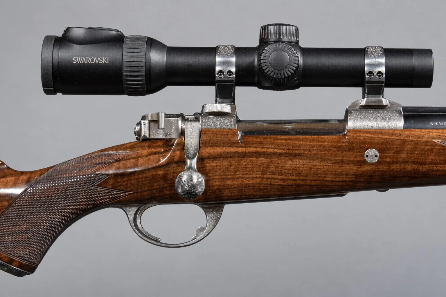 Editorial study of a sporting-arm action and bolt against a light neutral background