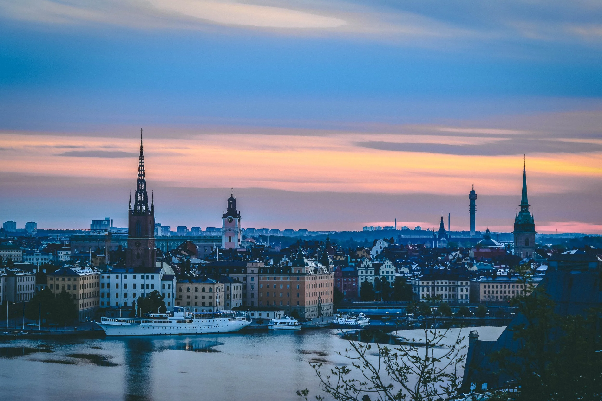 The city stirs beneath a golden hush.
Bathed in the soft glow of morning, the old skyline begins to wakeâits spires and rooftops whispering secrets to the rising sun. Each stone and silhouette holds a story, silent yet profound, waiting to be heard