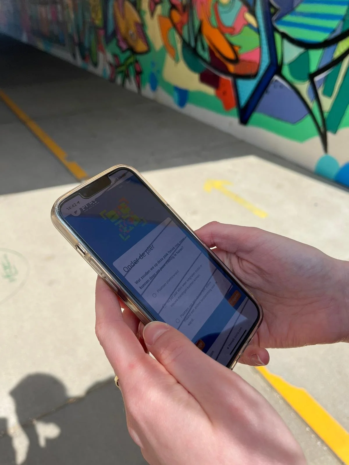 Persoon houdt een smartphone vast en kijkt naar een interactief element van de Tourio software voor het verkennen van de stad.