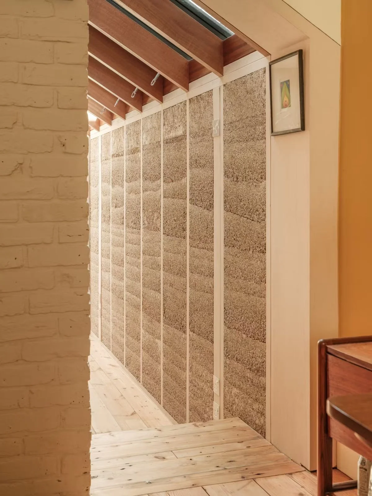 Exposed hempcrete wall panels with clay plaster interior finish