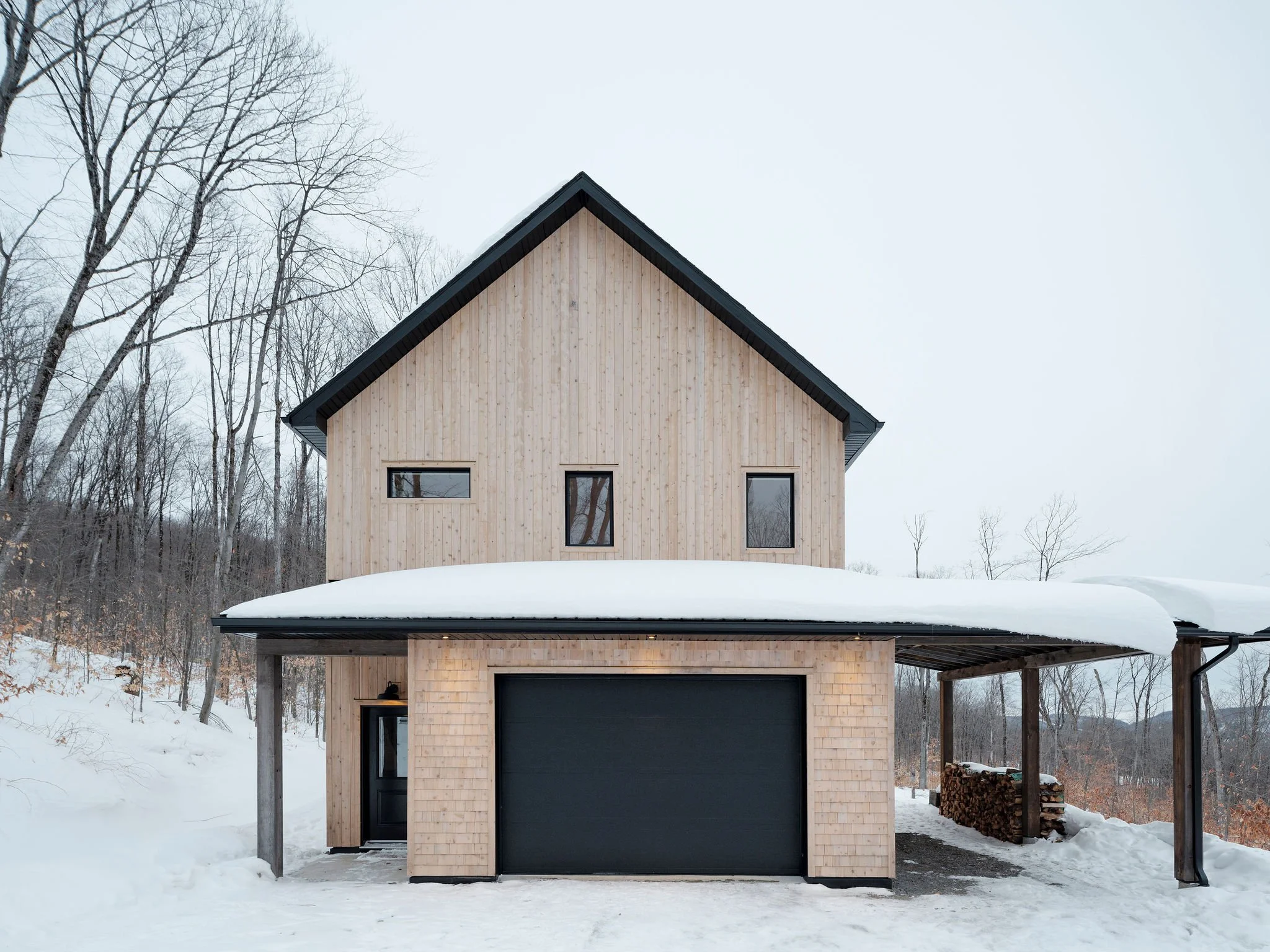 Scanidinavian style home in the Laurentians with snow covered roof and driveway