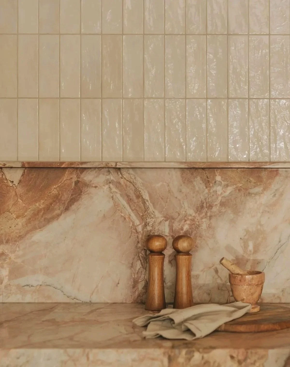 Marble kitchen counter with continued marble blacksplash that meets a subwaytile backsplash halfway
