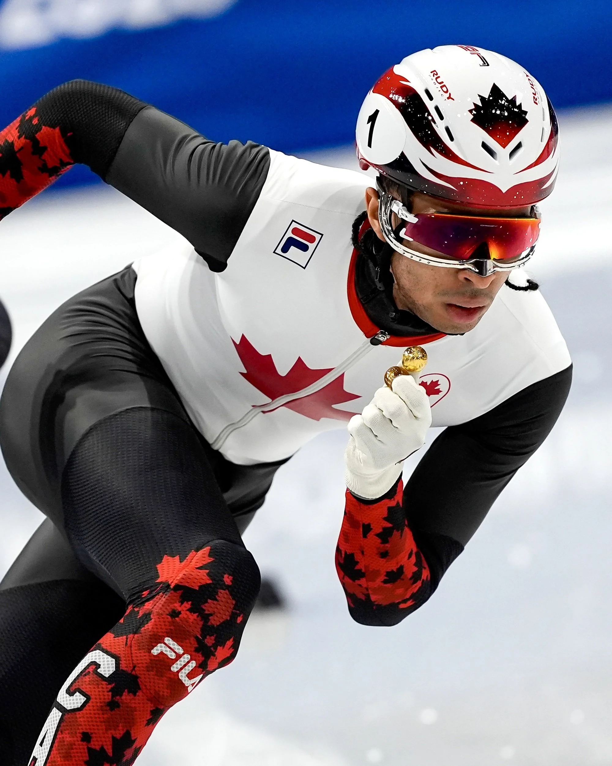 William Dandjinou, patineur de vitesse courte-piste. Portant le casque réalisé par Simon-Olivier Côté lors des Jeux Olympiques de Milan-Cortinage en 2026.