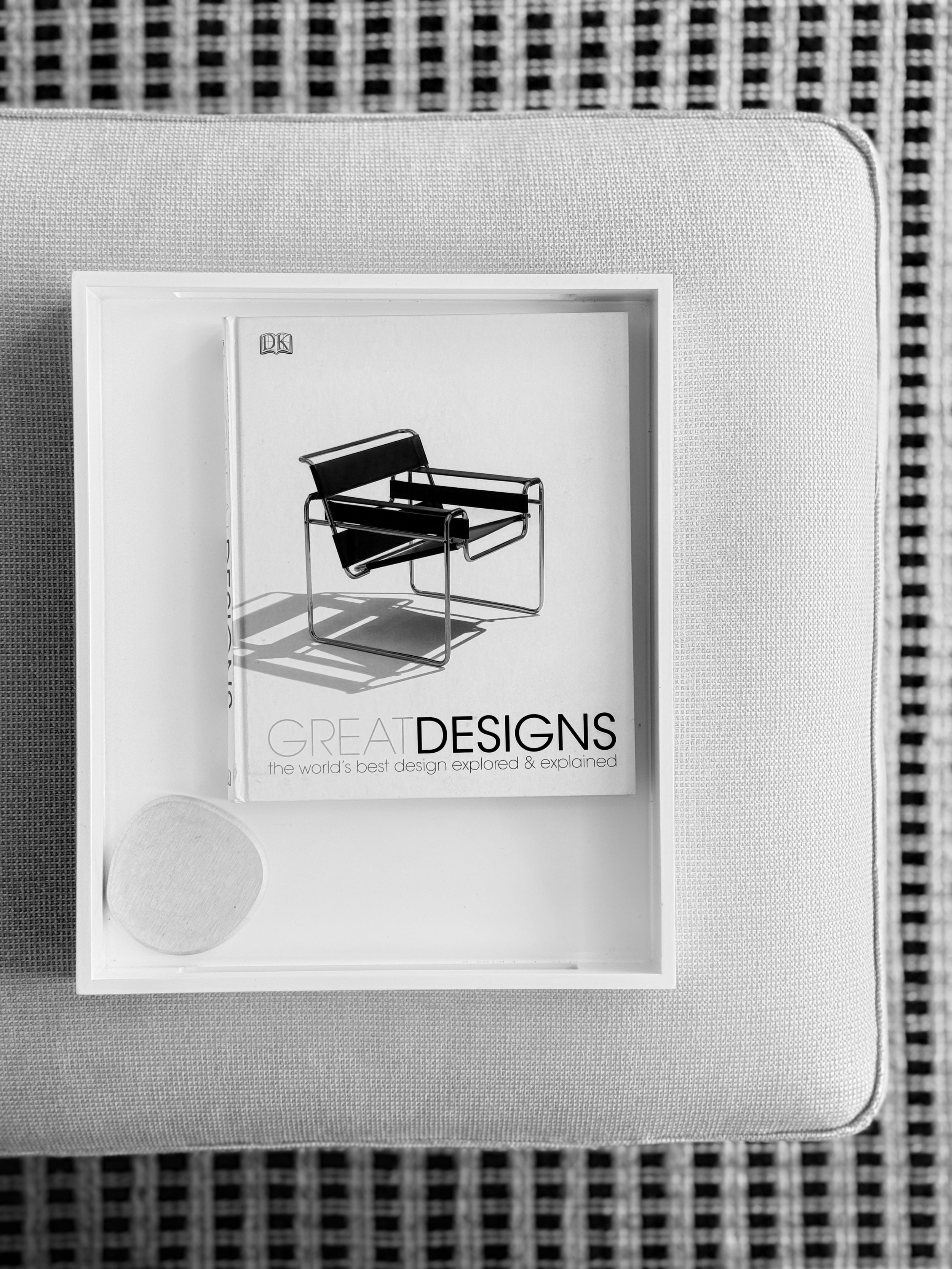 Black-and-white styling vignette with a Wassily chair and a design book, reflecting Roland Benke's composed coastal-luxury interior design aesthetic