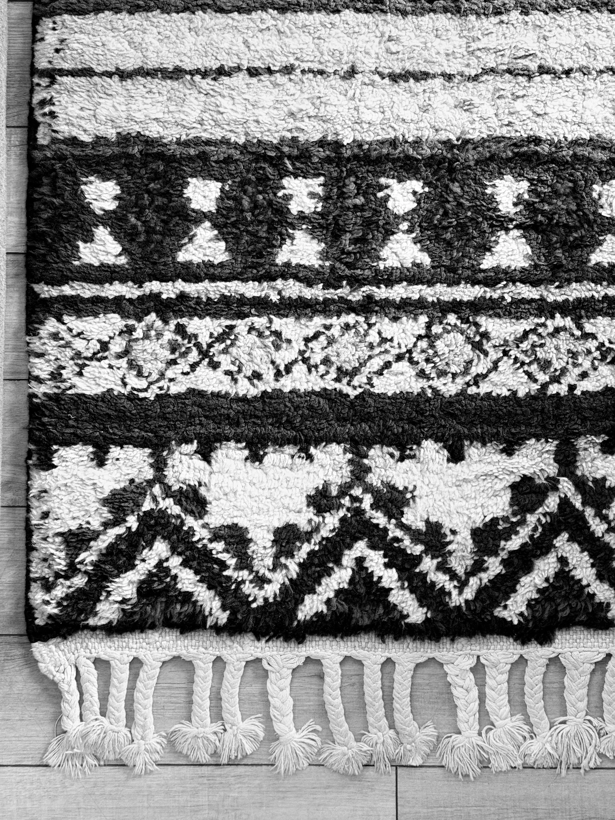 Close-up of a black-and-white patterned textile with tactile texture, illustrating the considered material and styling choices in Roland Benke's design process