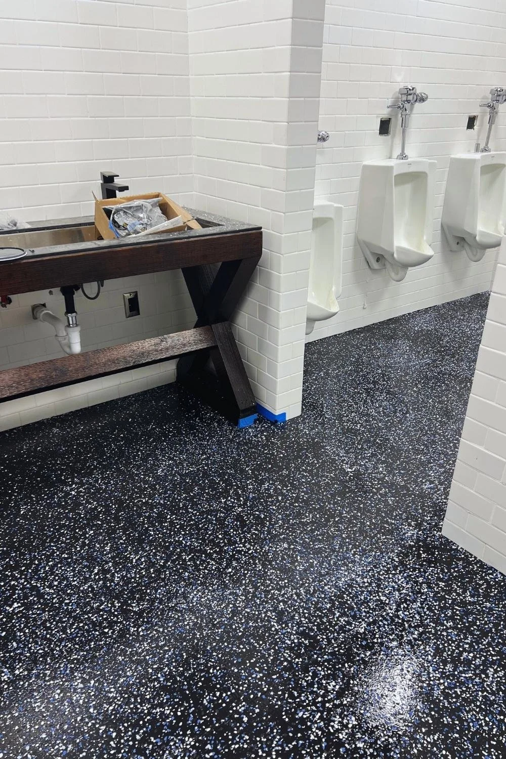 Commercial restroom renovation with terrazzo flooring and modern fixtures by JECAM