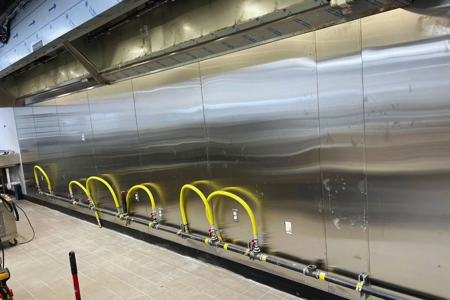 Commercial kitchen gas line and stainless steel wall installation by JECAM