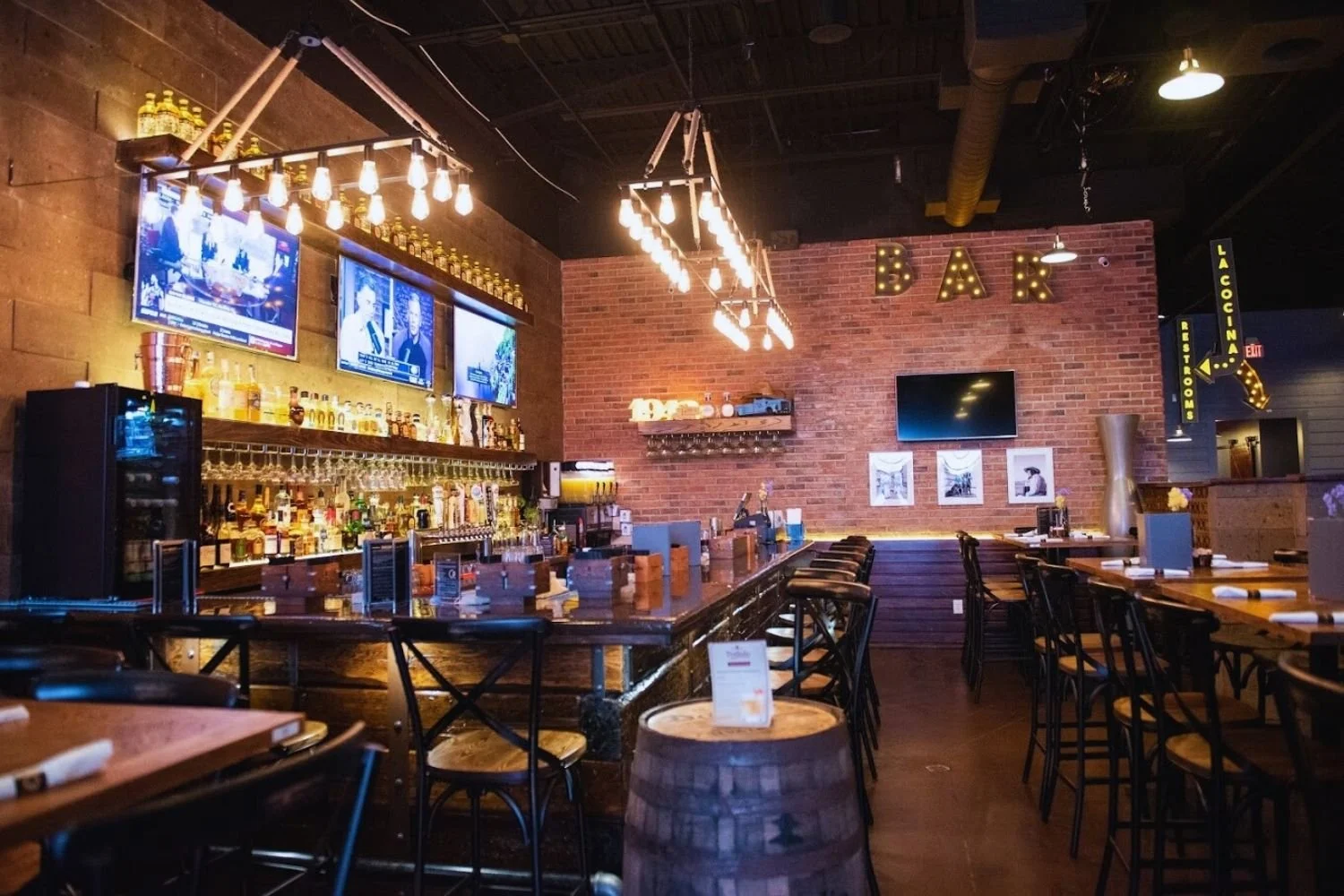 Modern bar and restaurant interior with brick walls and warm lighting by JECAM