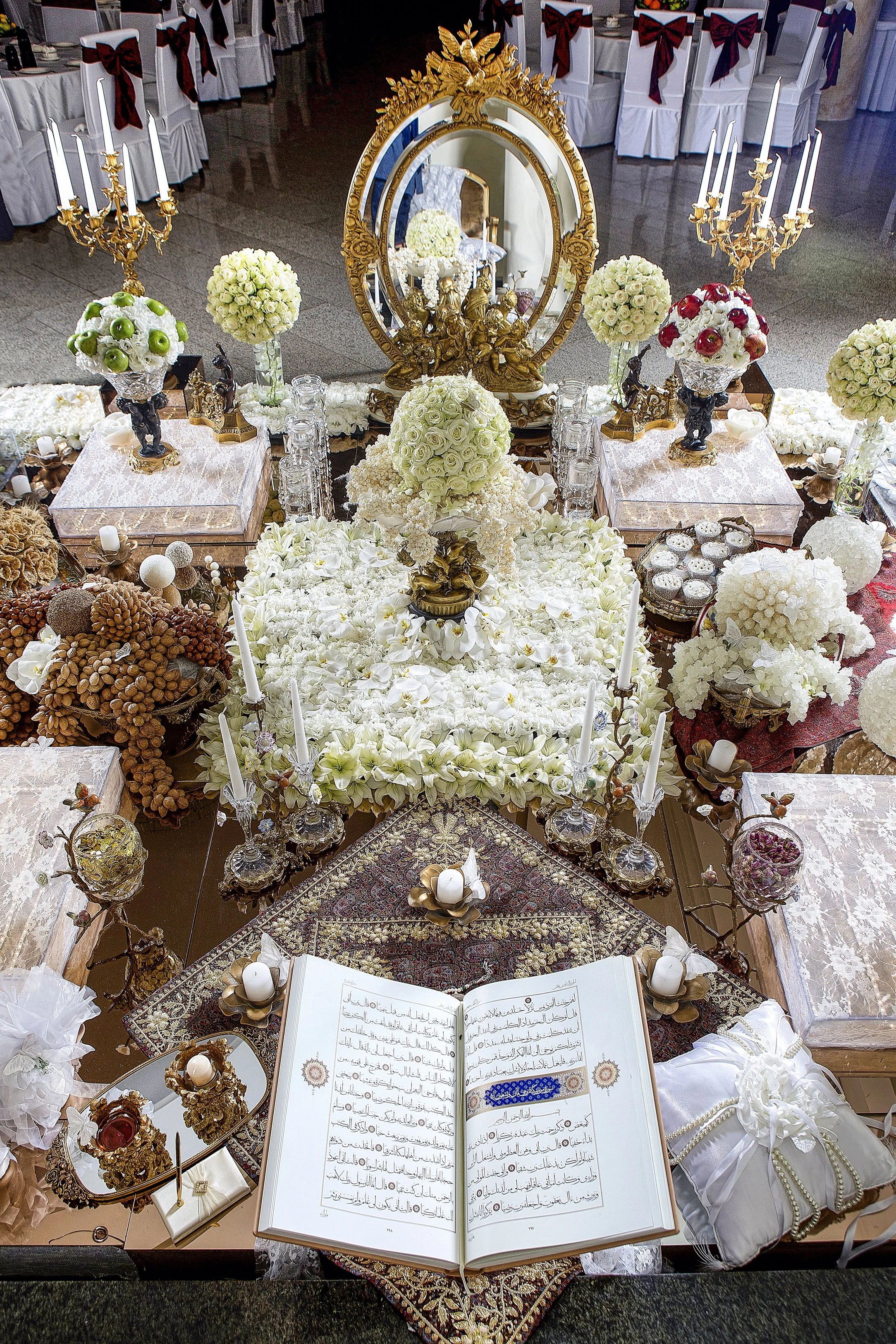 This photo captures an elaborate Persian wedding table spread, known as a Sofreh Aghd, an iconic tradition that incorporates various symbolic items, each carrying deep meaning for the couple's new life together.