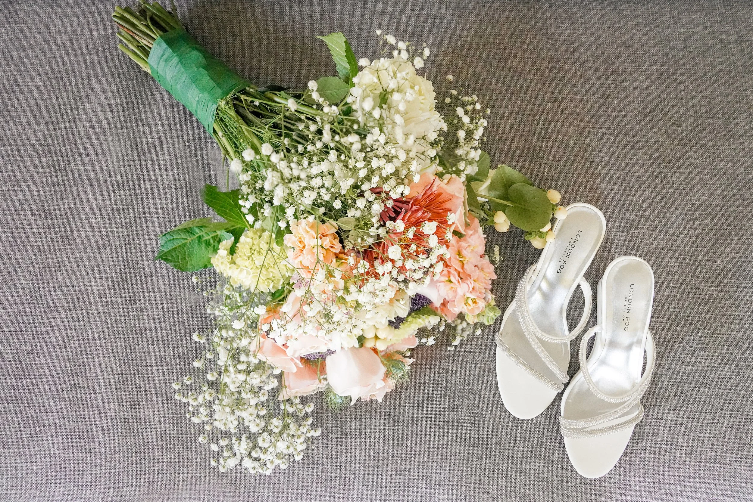 Elegant wedding day details including a lush floral bridal bouquet and sparkling white strappy heels.