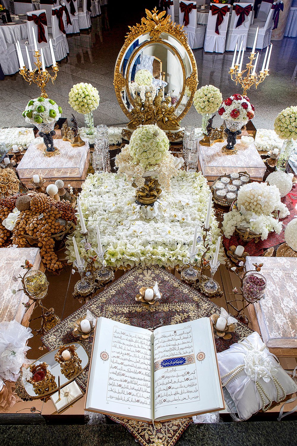 This photo captures an elaborate Persian wedding table spread, known as a Sofreh Aghd, an iconic tradition that incorporates various symbolic items, each carrying deep meaning for the couple's new life together.
