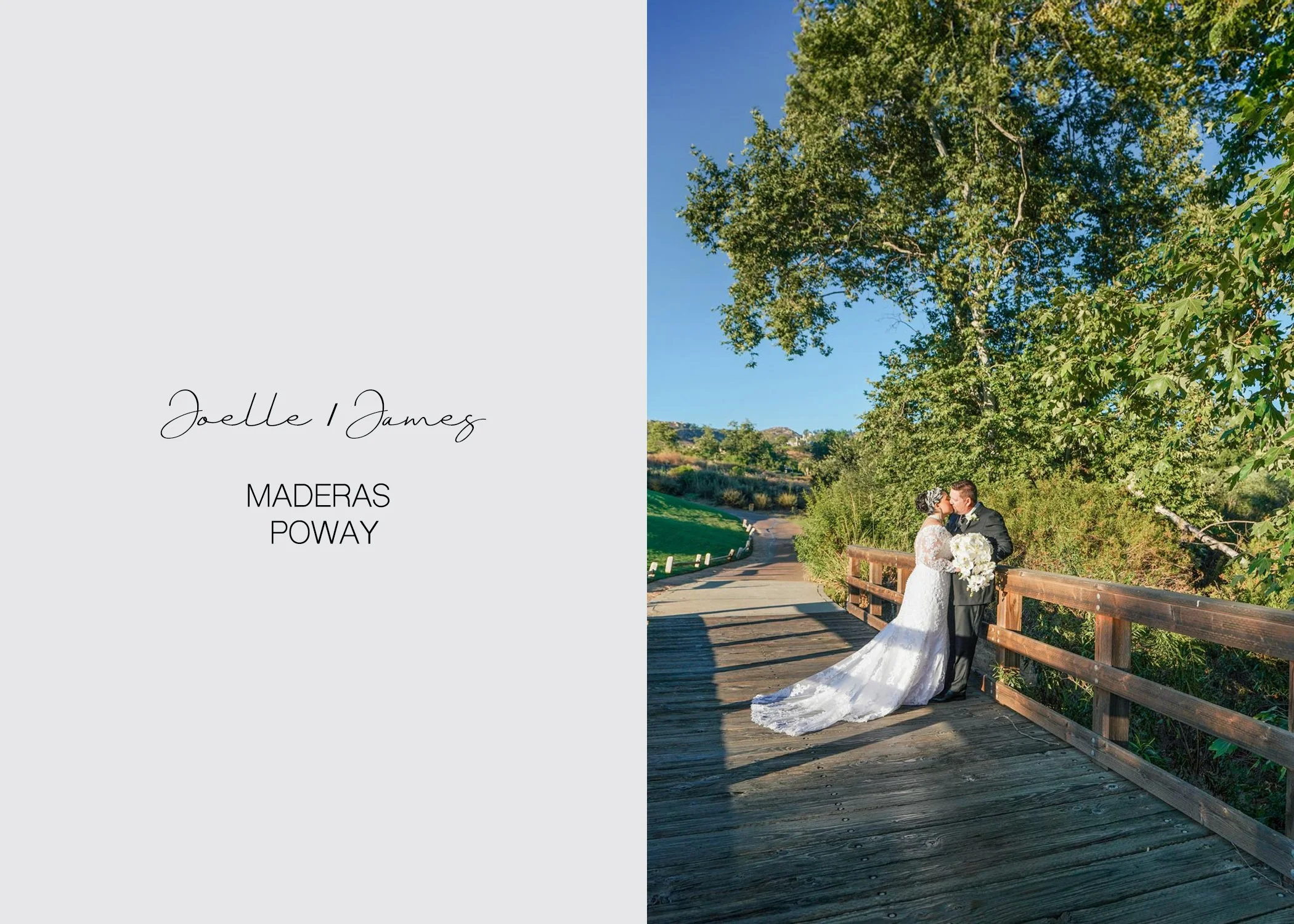 A newly married couple shares a moment and a kiss on a wooden bridge surrounded by lush, green trees and foliage. The outdoor, sunlit setting creates a romantic and natural atmosphere. The bride, in a white lace wedding dress with a full skirt and lo