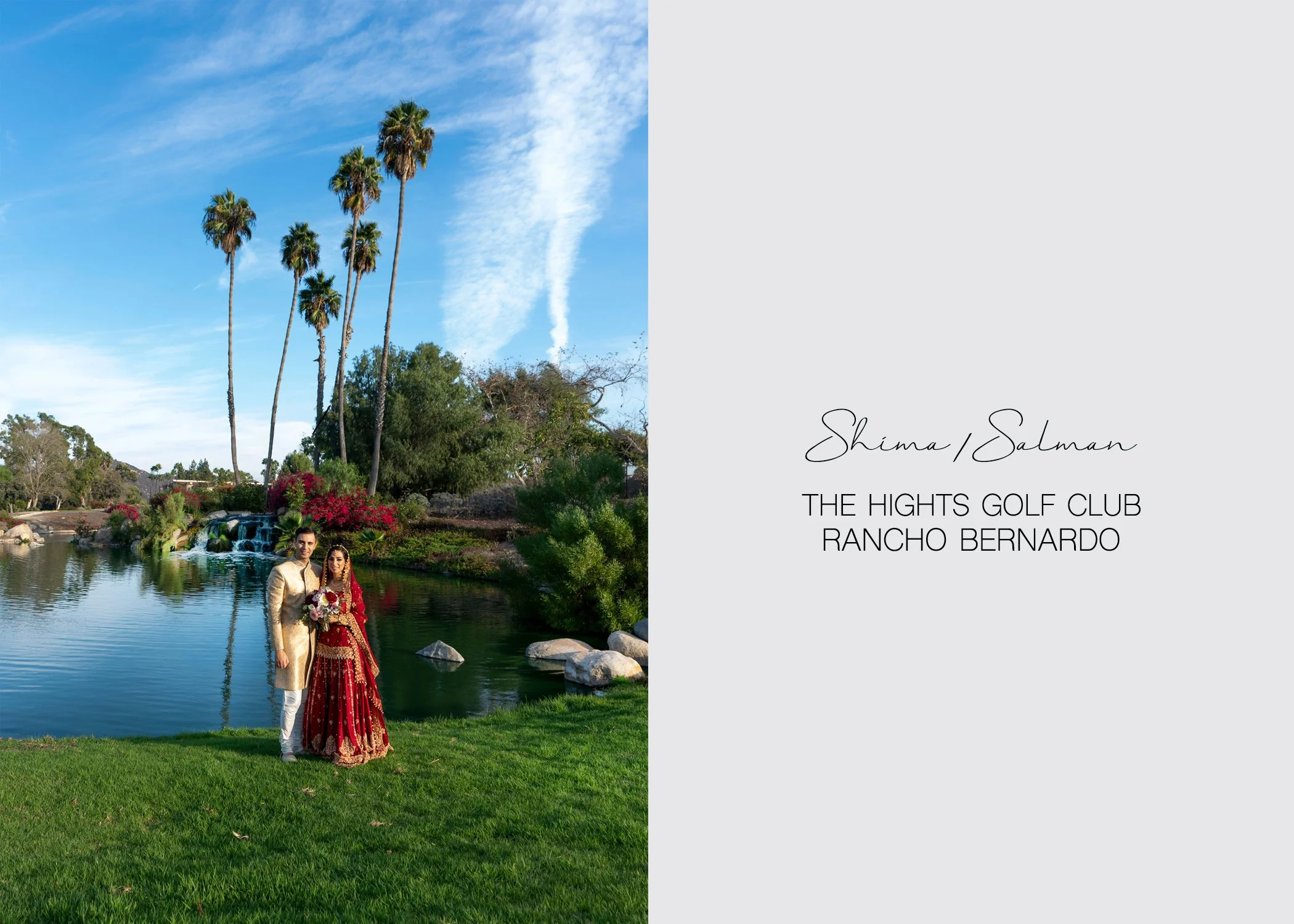 A stunning South Asian wedding portrait features the newly married couple standing on lush green grass next to a serene pond and a picturesque waterfall, framed by tall palm trees reaching up to a bright blue sky with wispy white clouds. The setting 