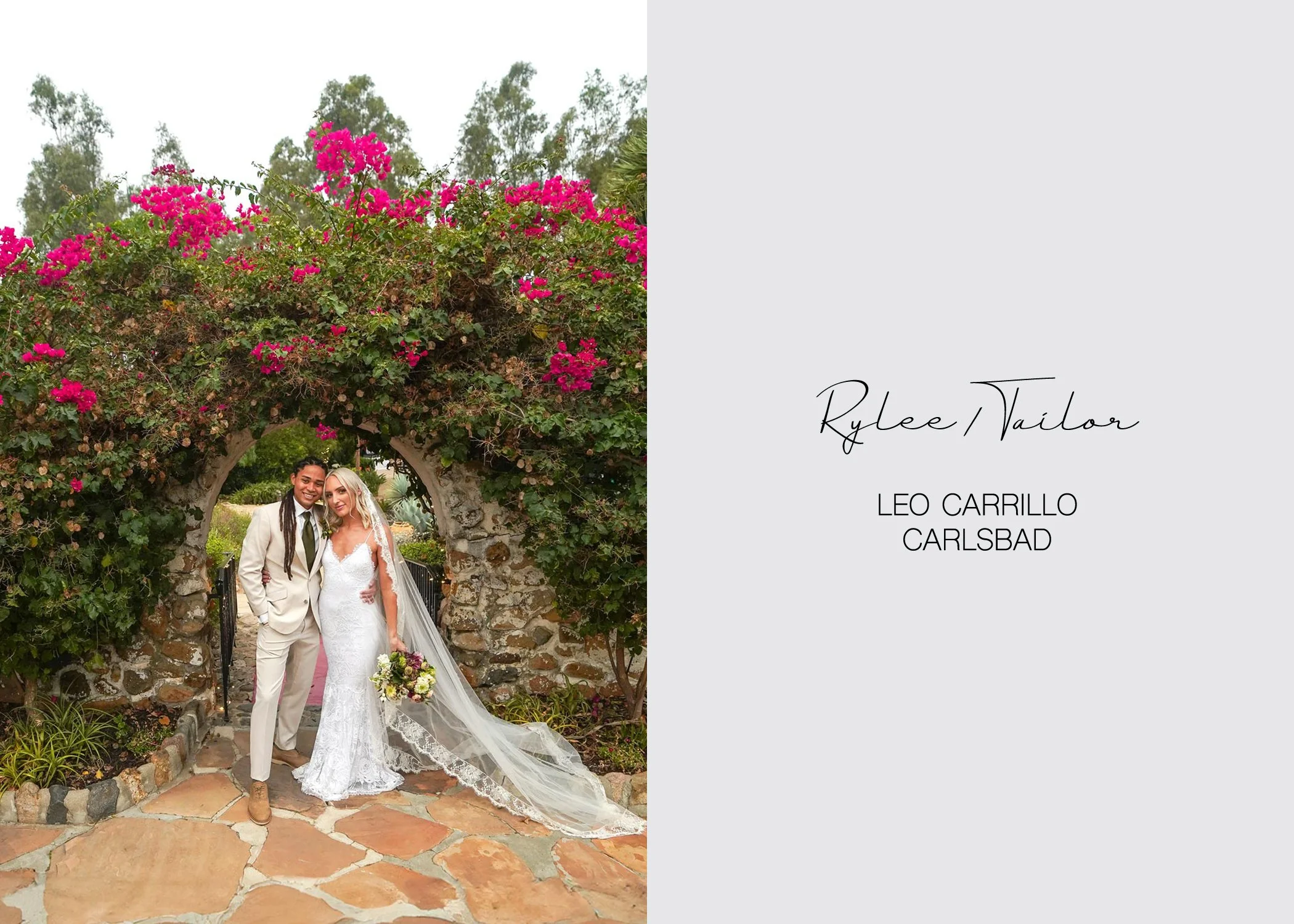 A newly married couple poses for a portrait under a stone archway adorned with vibrant pink bougainvillea in Carlsbad. They are both smiling at the camera in a lush, green outdoor setting.
