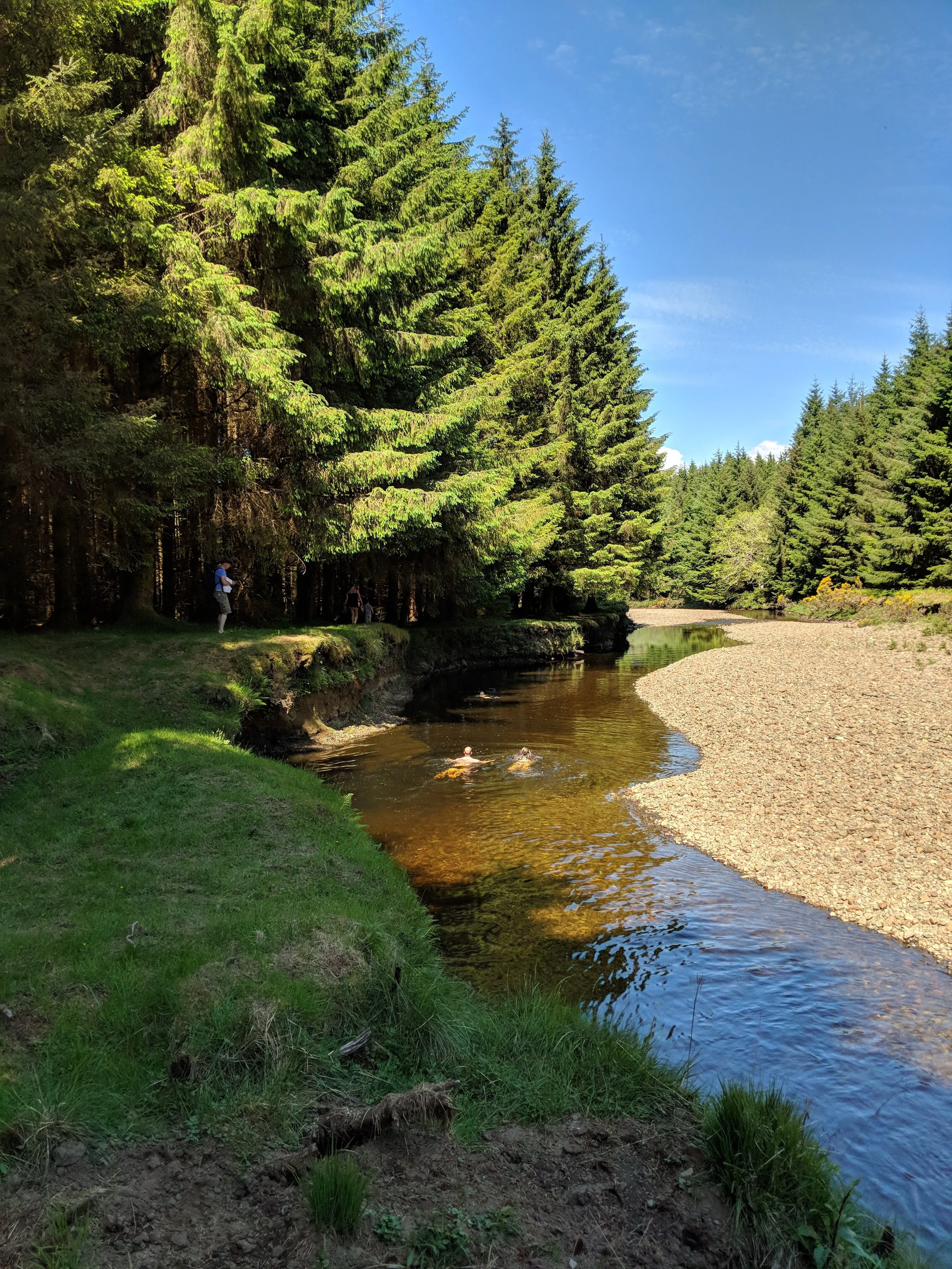 People swimming along a beautiful river in Scotland