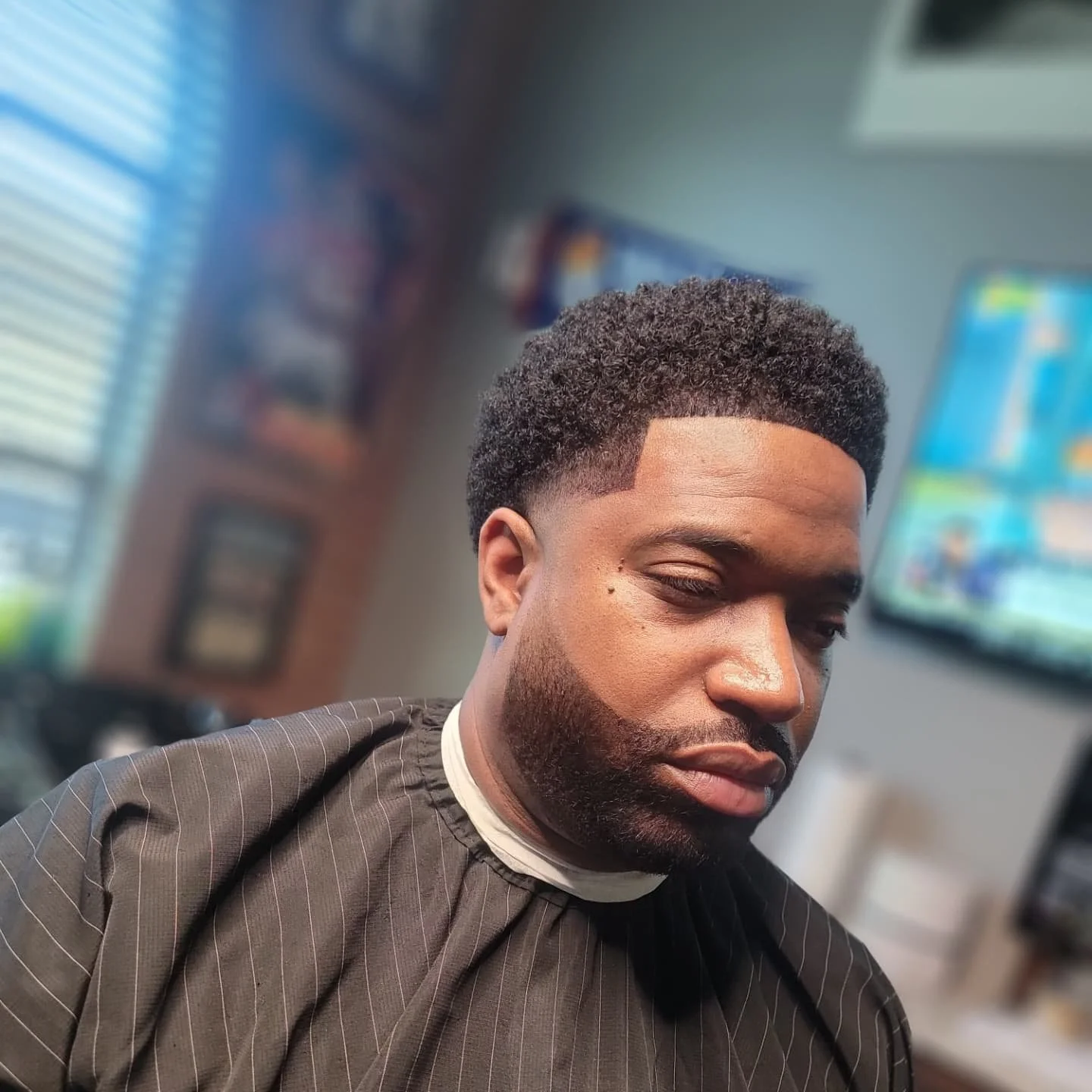 Young man with a fresh high fade haircut in a barbershop.