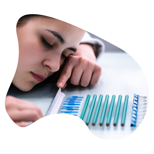 Person carefully measuring and lining up pencils with a ruler, symbolizing perfectionistic attention to order.