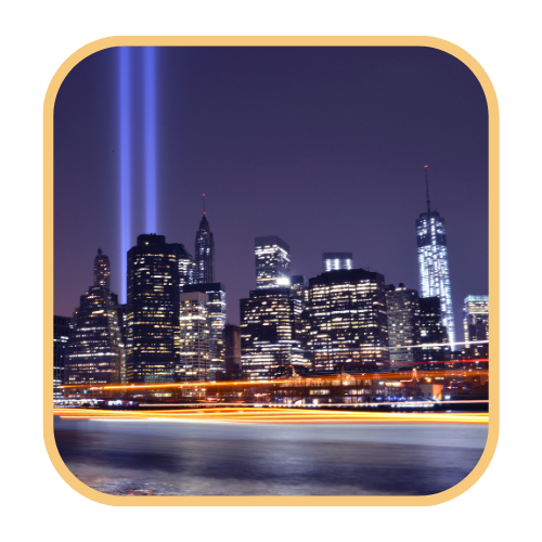 The Tribute in Light memorial — two beams of blue-white light rising into the night sky above the Manhattan skyline.