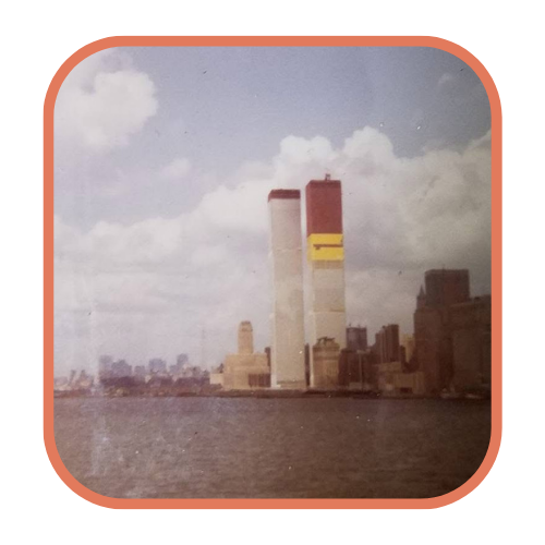 A vintage photo of the Twin Towers under construction, viewed from across the Hudson River.