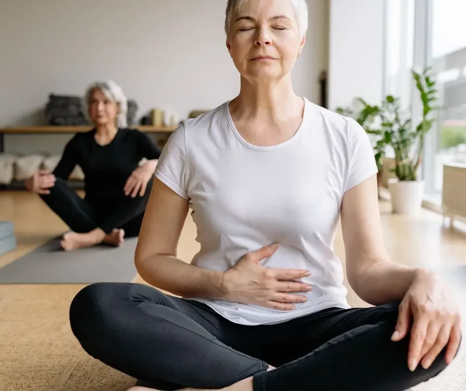 Woman practicing mindful breathing and meditation to support stress management, emotional wellbeing, and nervous system regulation during perimenopause and menopause.