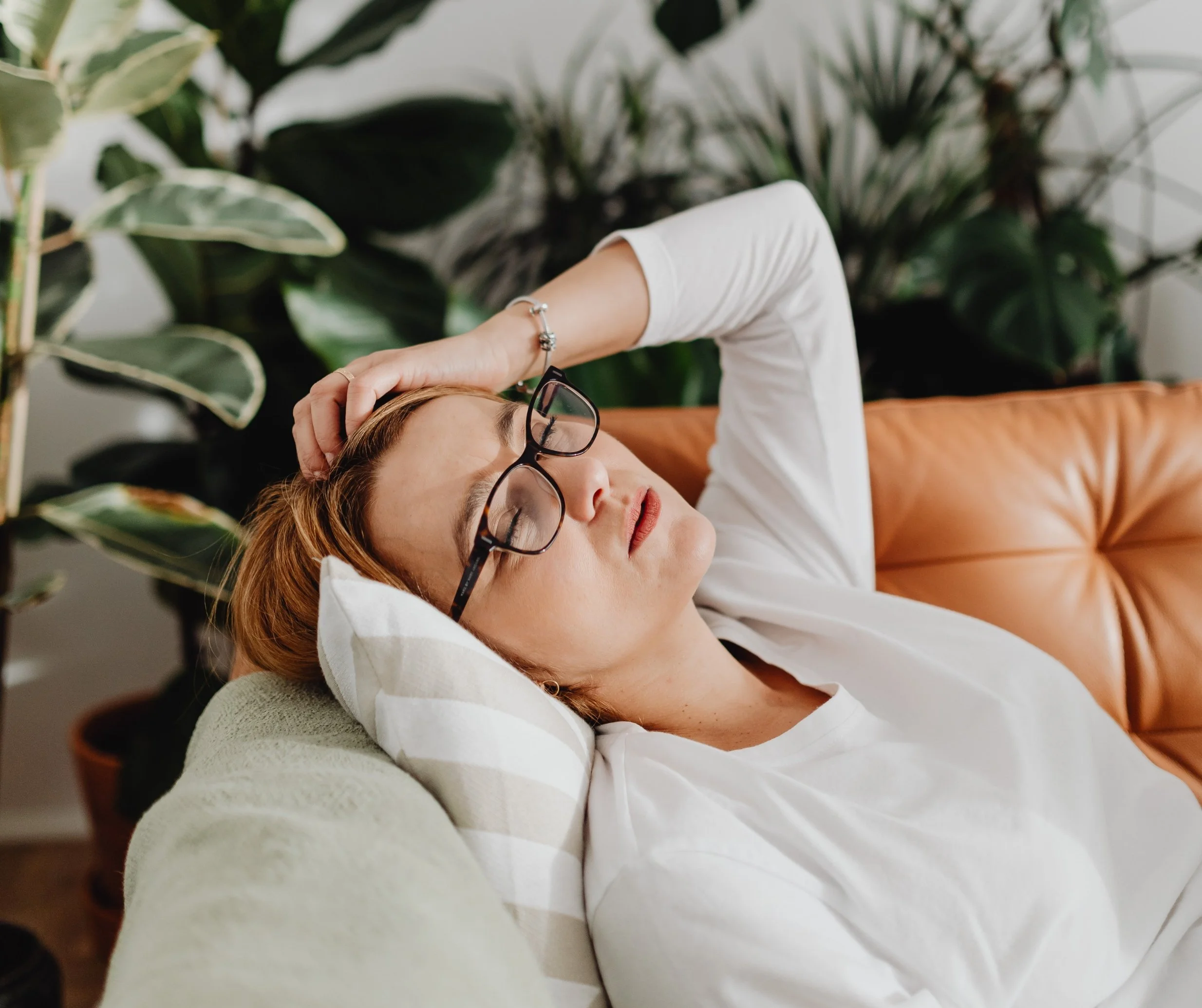 Exhausted woman lying down at home experiencing burnout and fatigue