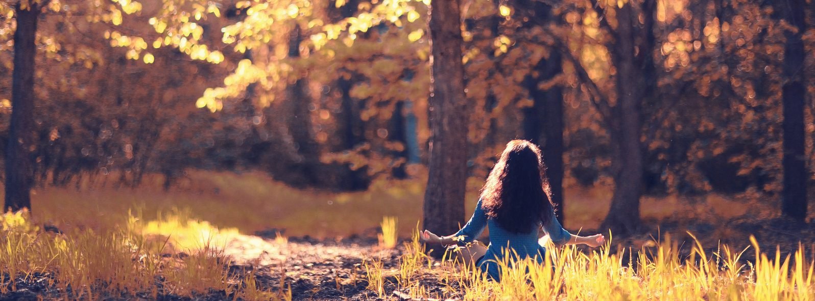 Person meditating peacefully in nature to represent healing, balance, and supportive integrative health care