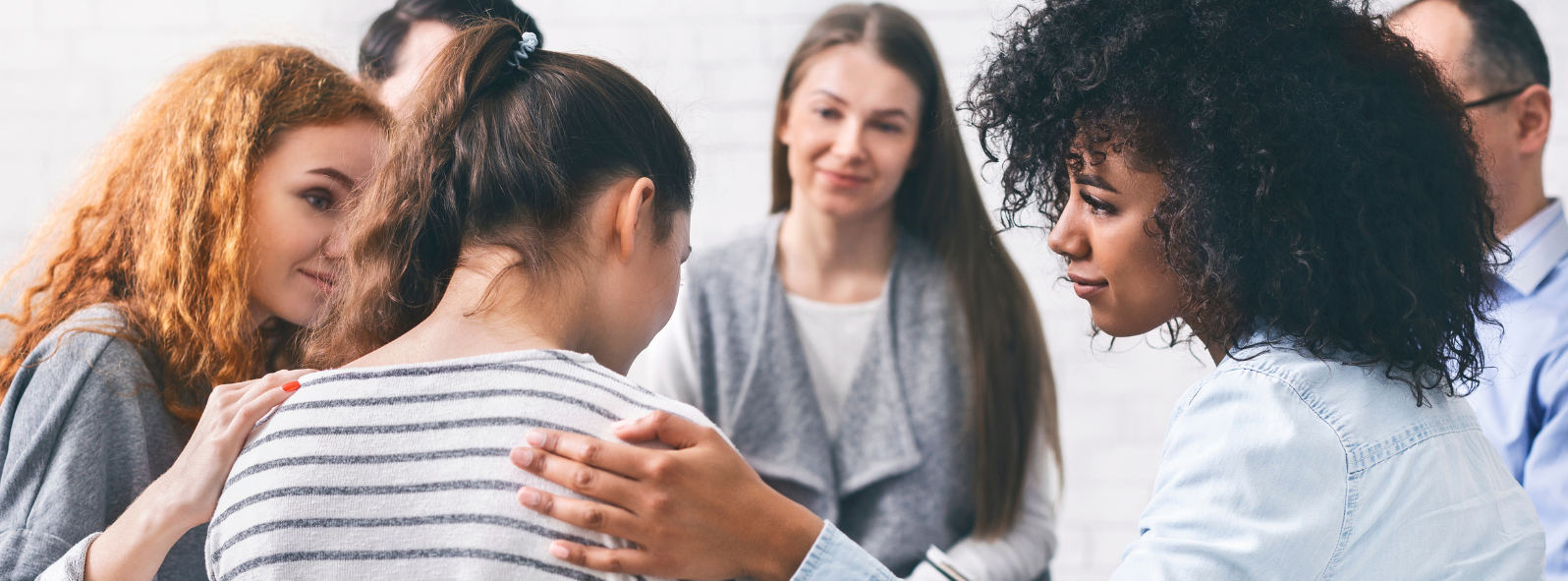 Supportive group therapy session with individuals offering comfort and connection in a mental health counselling setting focused on emotional wellness and healing in East St. Paul.