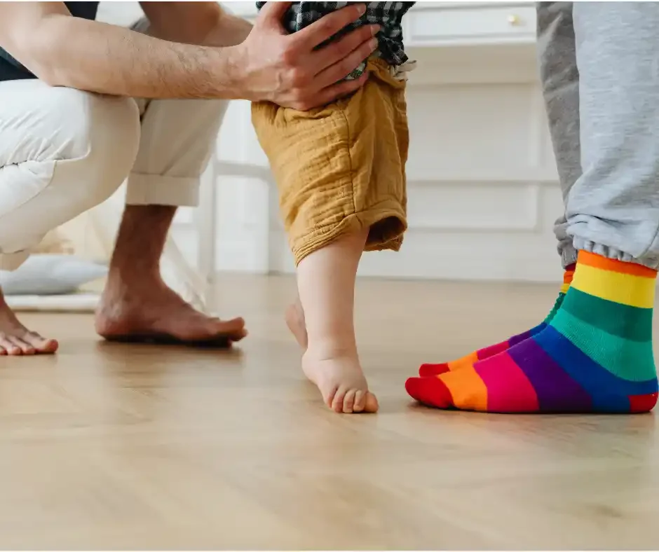 Young child taking supported first steps with parents, representing healthy growth, development, and pediatric care at True Health Integrative Clinic in Winnipeg.
