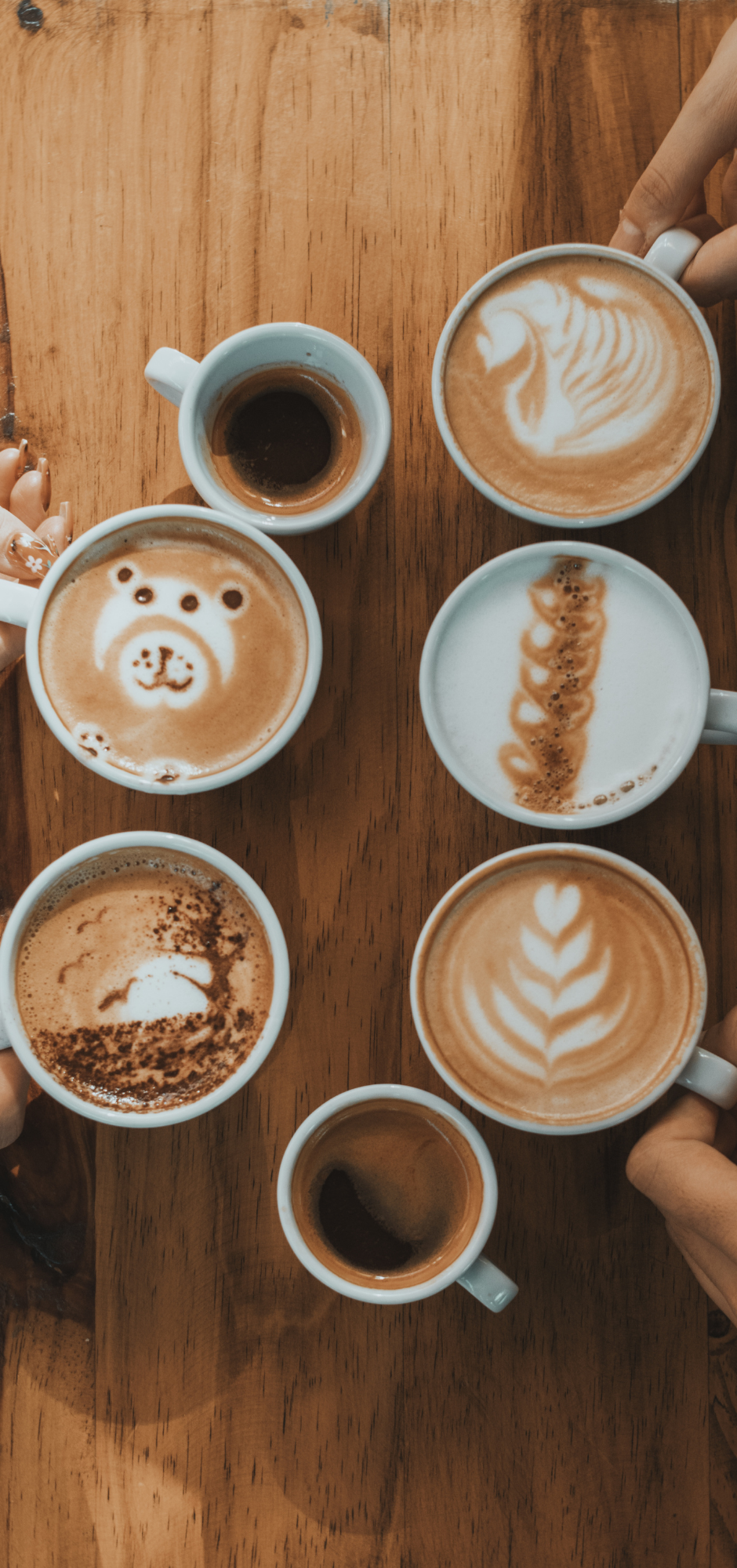Assorted coffee drinks on a wooden table, representing reliance on caffeine to manage fatigue and low energy at True Health Integrative Clinic in Winnipeg.