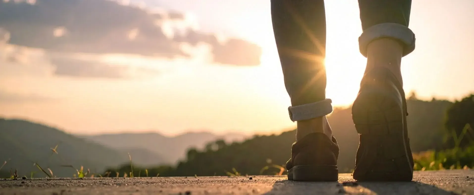 Person walking toward the sunrise, representing collaborative, patient-centred healthcare and progress toward better health.