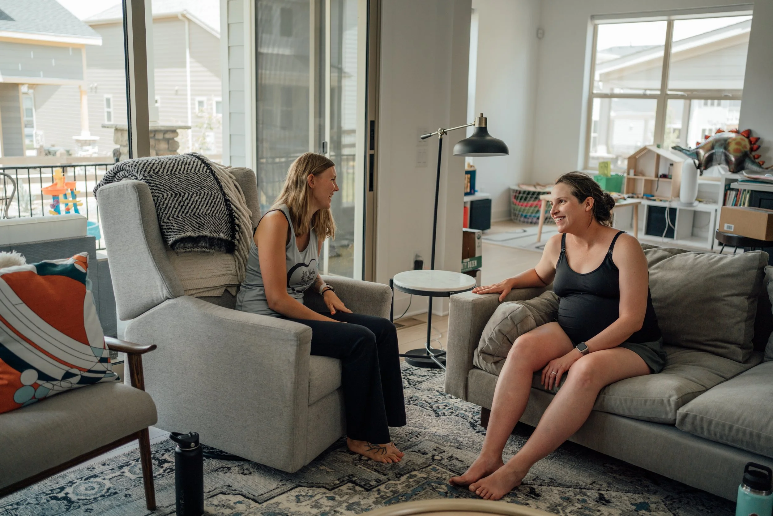 Doula and pregnant mother talking in a home, preparing for a home birth.