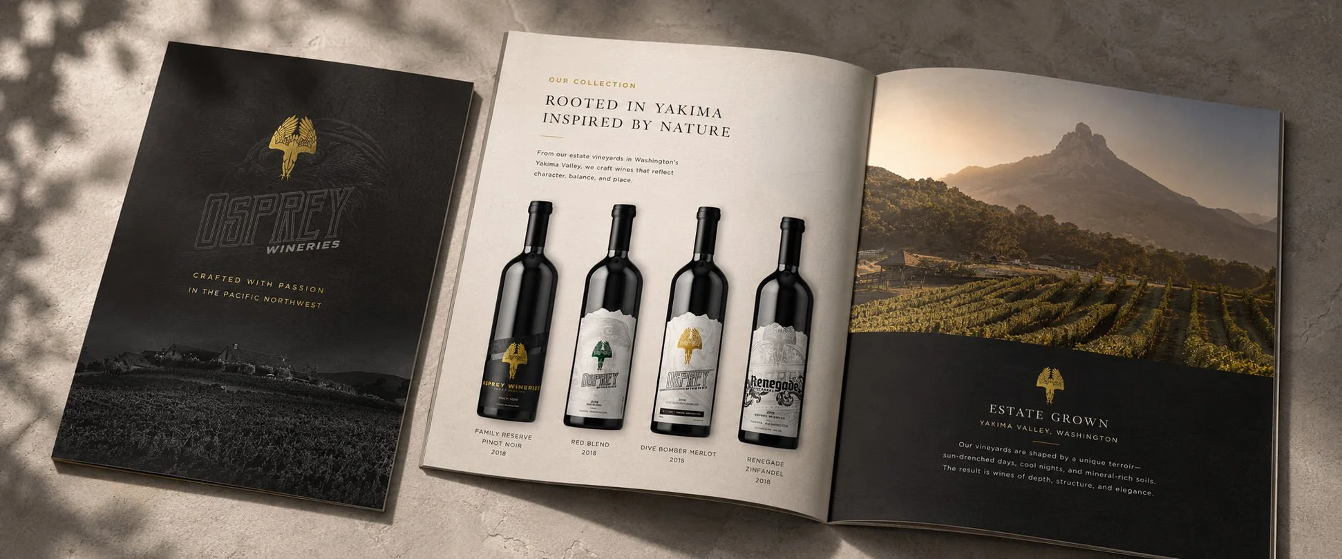 Open magazine and booklet displaying bottles of wine from Osprey Wineries, with a scenic vineyard landscape and mountains in the background. Work by South of LA.
