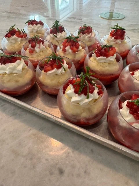 Strawberry and cream desserts served in small glass cups, garnished with fresh strawberries and mint.