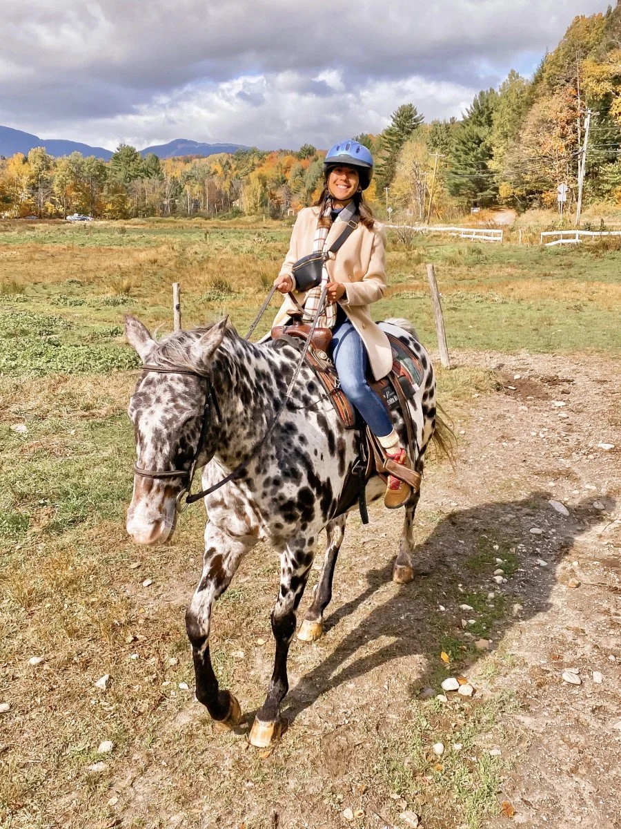 woman horseback riding on spotted horse