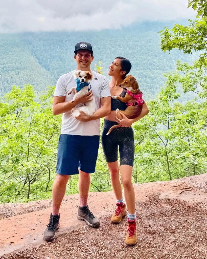 couple hiking with two dogs