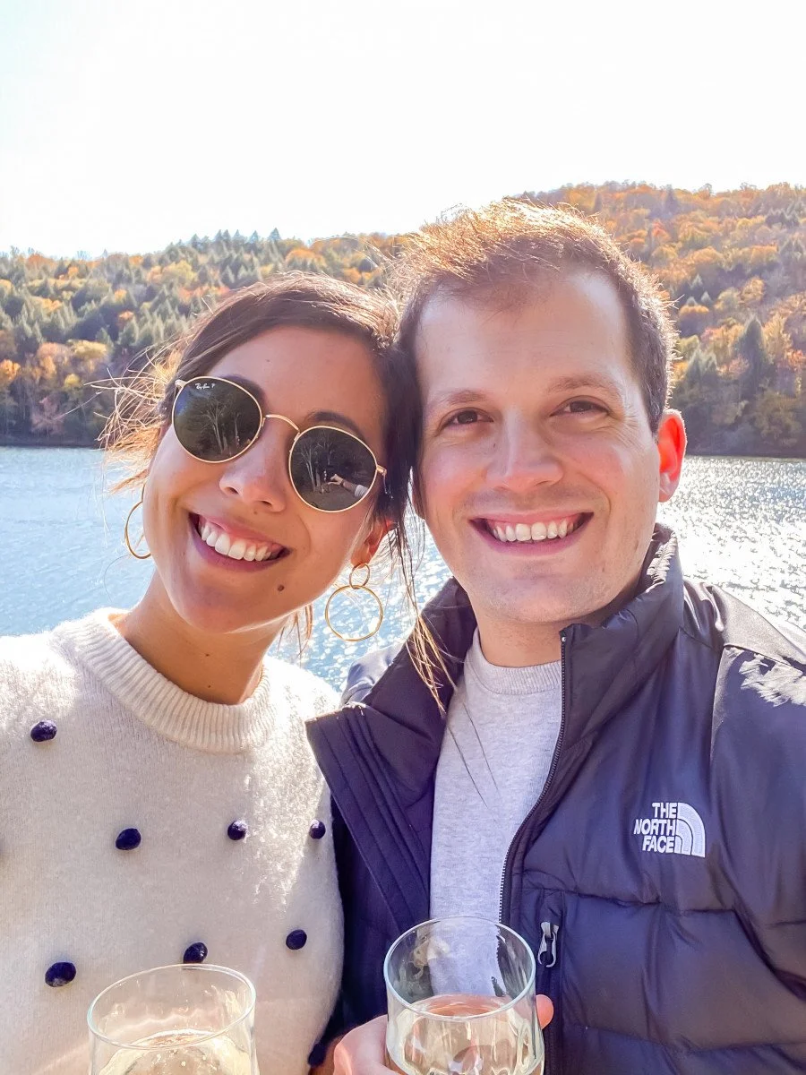 couple enjoying beers in front of lake