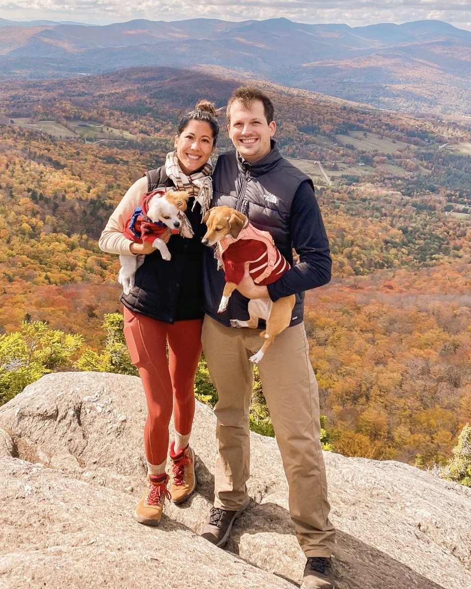 couple holding dogs with beautiful fall foilage views