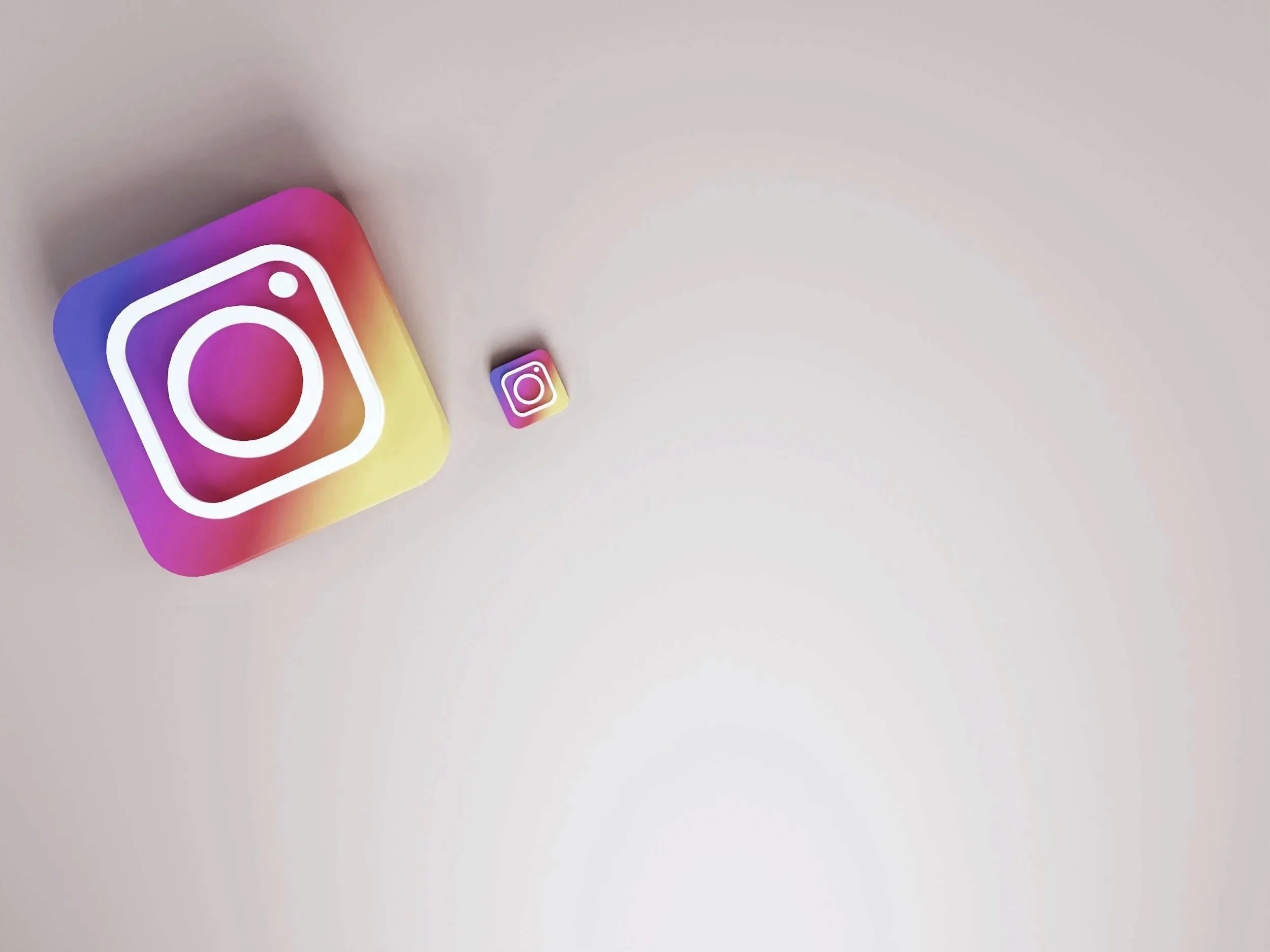 Three Instagram app icons in varying sizes on a plain background, with the largest icon on the left and the smallest in the middle.