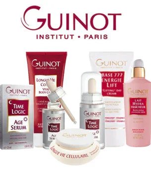 Scenic view of a mountain range in the distance with a calm body of water in the foreground, some small trees, and a wooden structure on the right side.