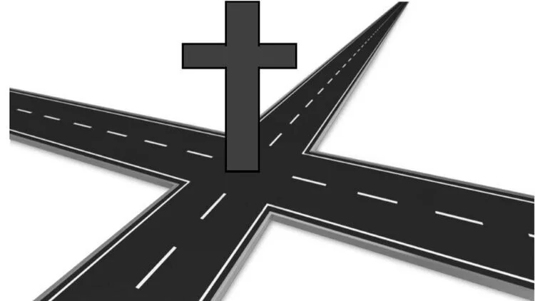 An illustration of a three-way intersection with roads, a cross symbol, and dashed lane markings.