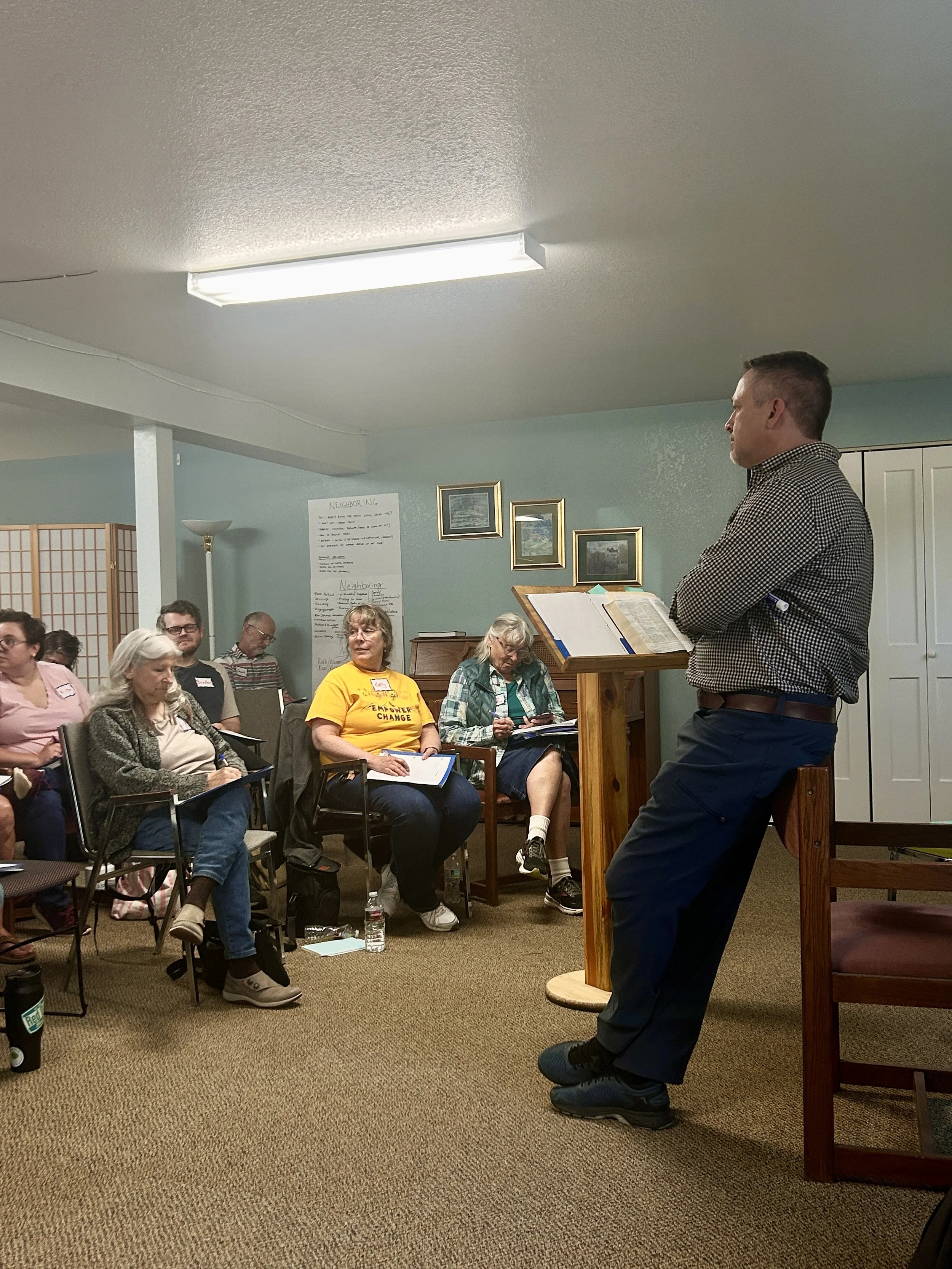 Logo for neighborhood gatherings with three stylized figures in red, blue, and orange, surrounded by text and symbols indicating 1,000 neighborhood gatherings and the abbreviation COS.