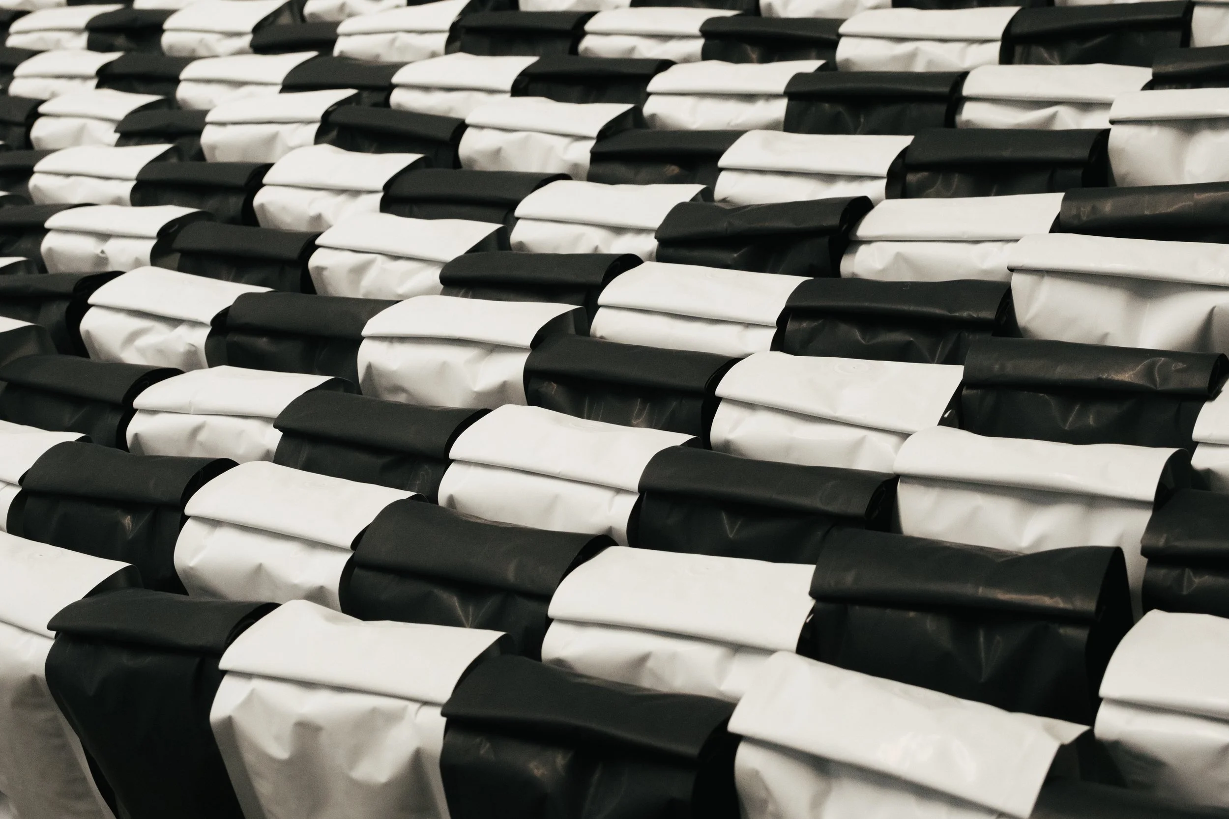 Multiple rows of black and white paper packages arranged in an alternating pattern.