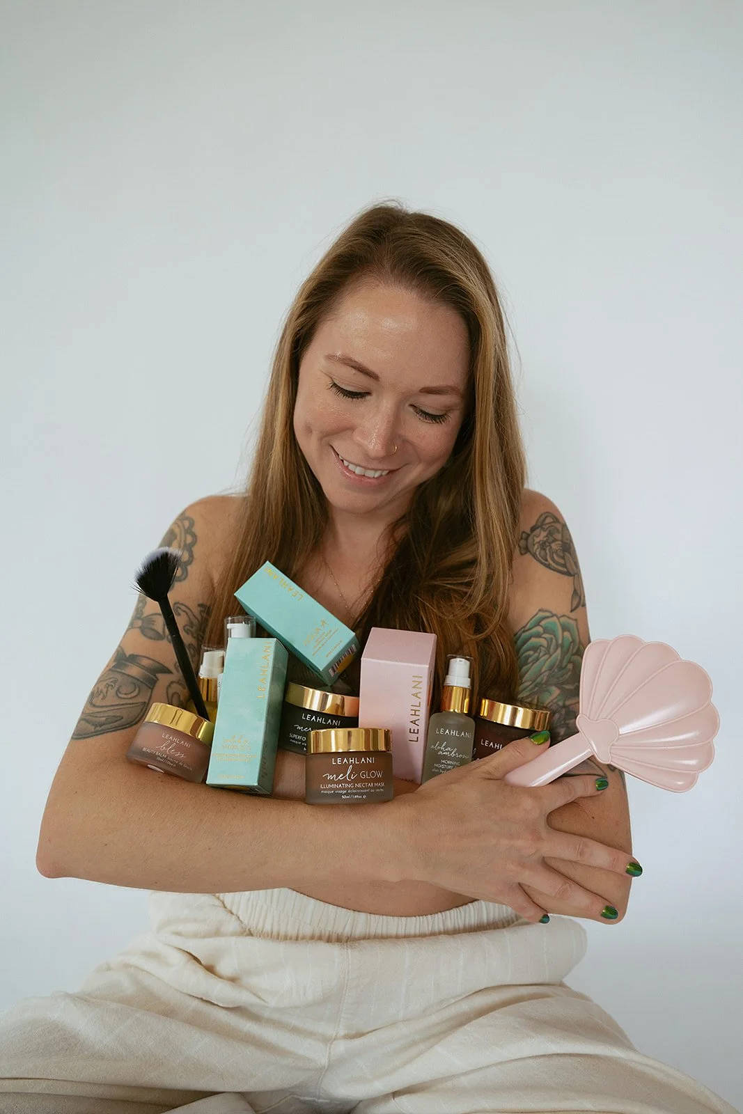 esthetician holding an arm full of holistic botanical skincare products